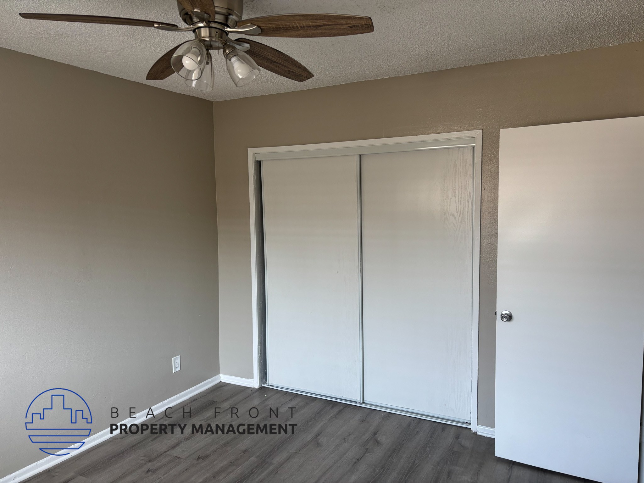 , A room with a ceiling fan and a sliding door.,A room with a ceiling fan and a sliding door.